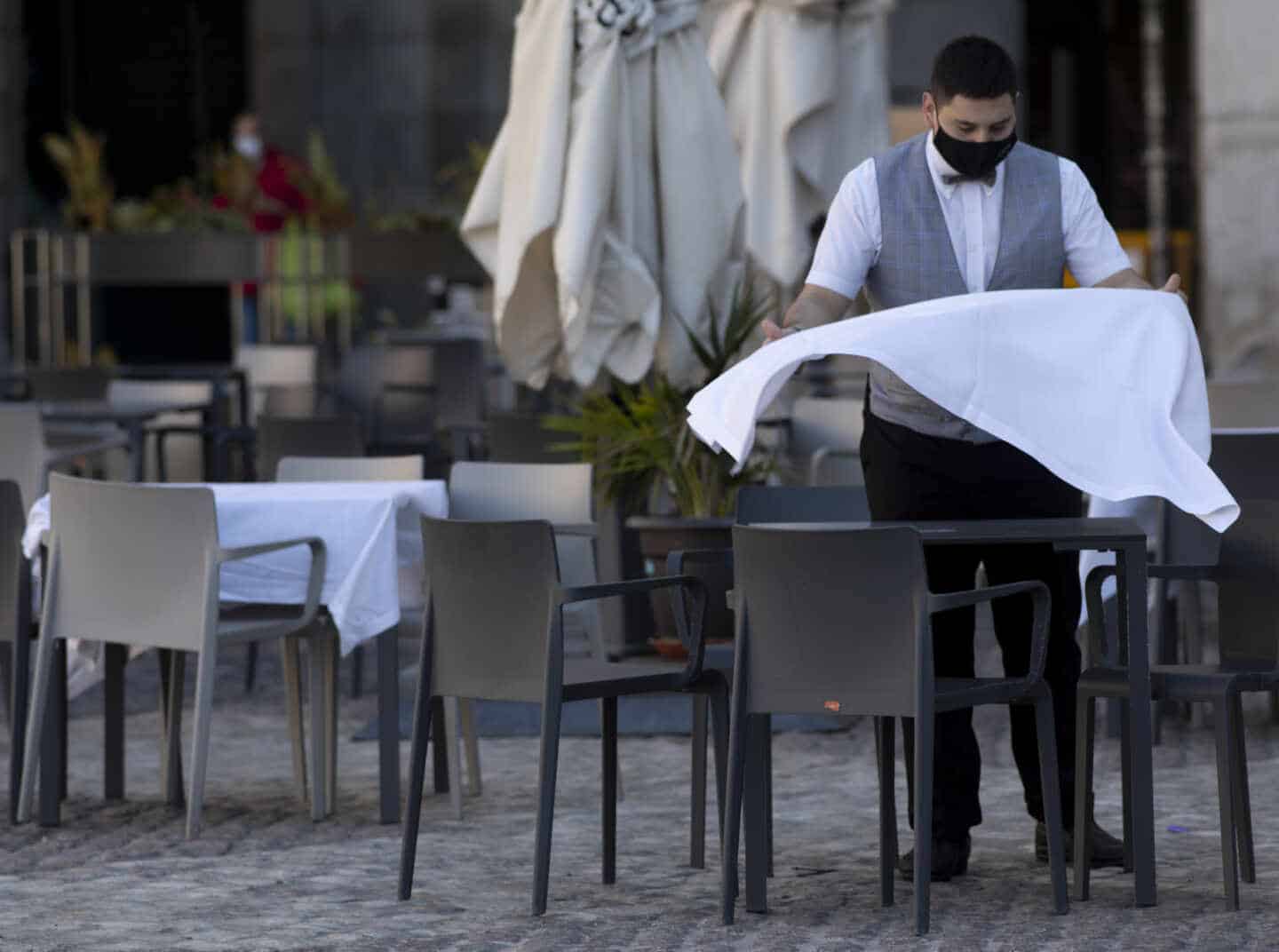 Un camarero prepara la mesa de una terraza de un establecimiento ubicado en la Plaza Mayor