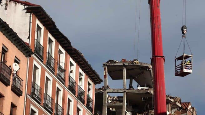 Un grúa durante el desmontaje del edificio siniestrado en el número 98 de la calle Toledo, en Madrid