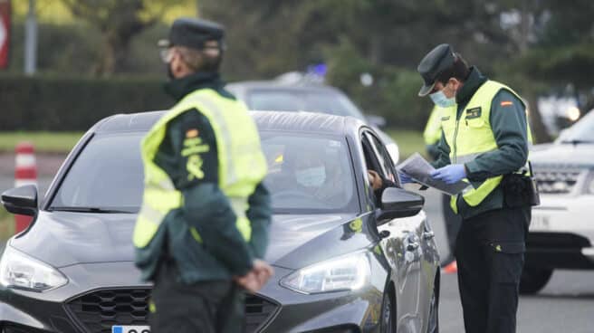 Un agente de la Guardia Civil pide la documentación a un vehículo durante un control efectuado en Laredo, Cantabria.