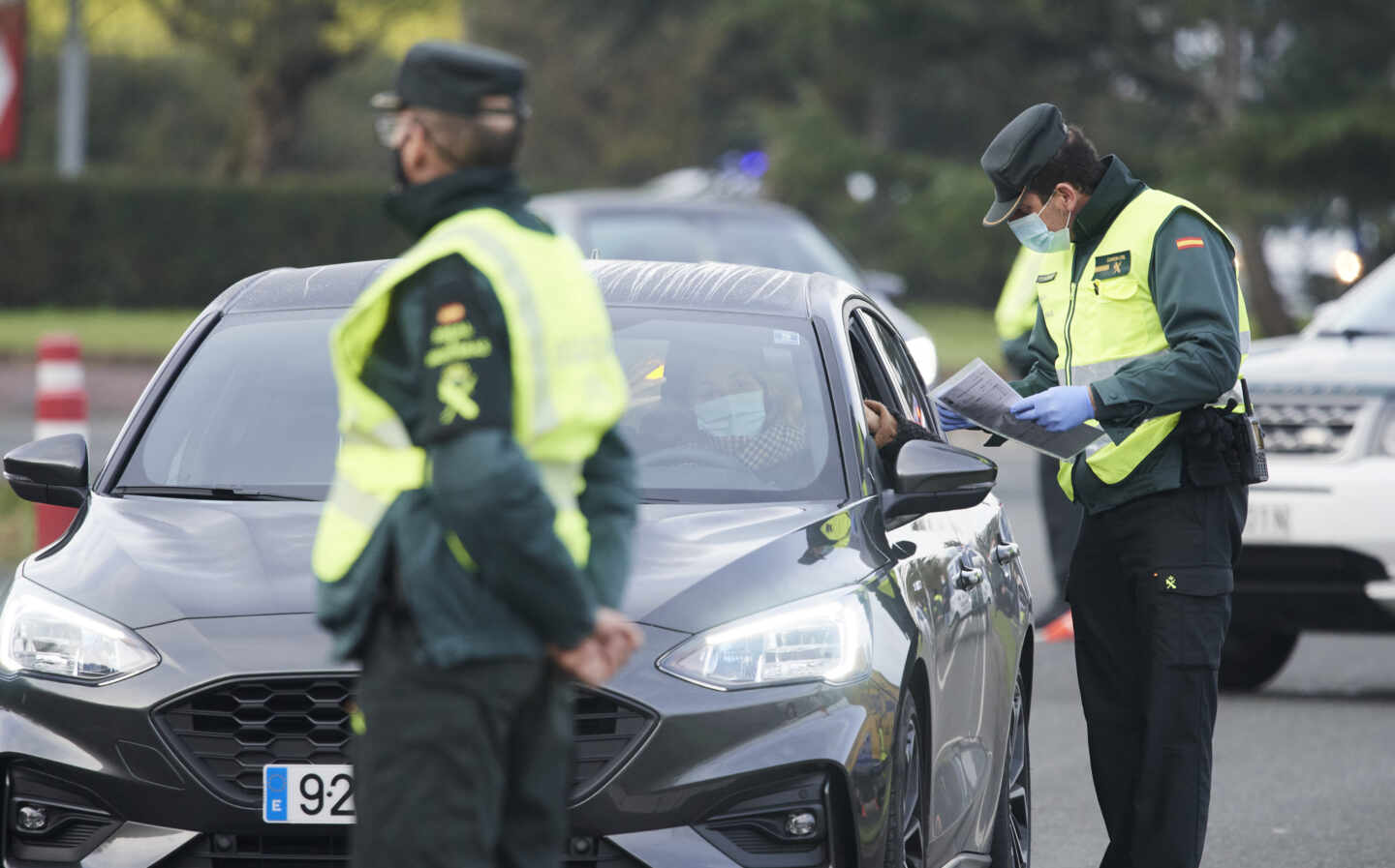 Un agente de la Guardia Civil pide la documentación a un vehículo durante un control efectuado en Laredo, Cantabria.
