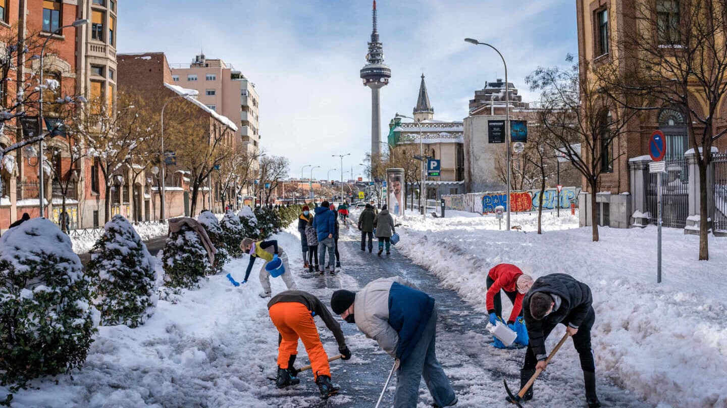 Madrileños limpian de nieve la calle