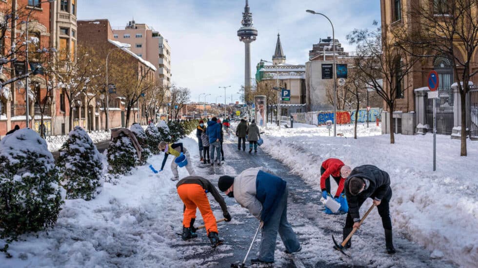 Madrileños limpian de nieve la calle