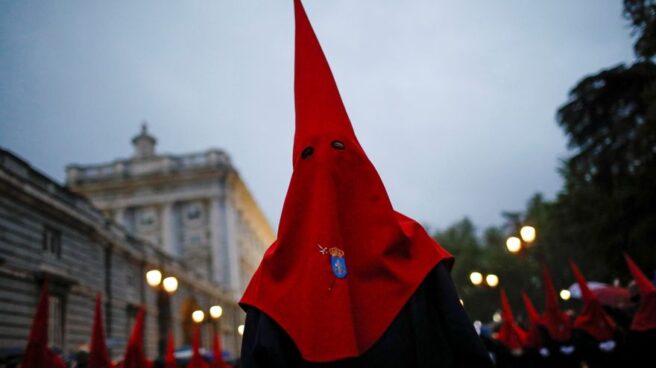 Un nazareno con un capirote de color rojo en una procesión de Semana Santa