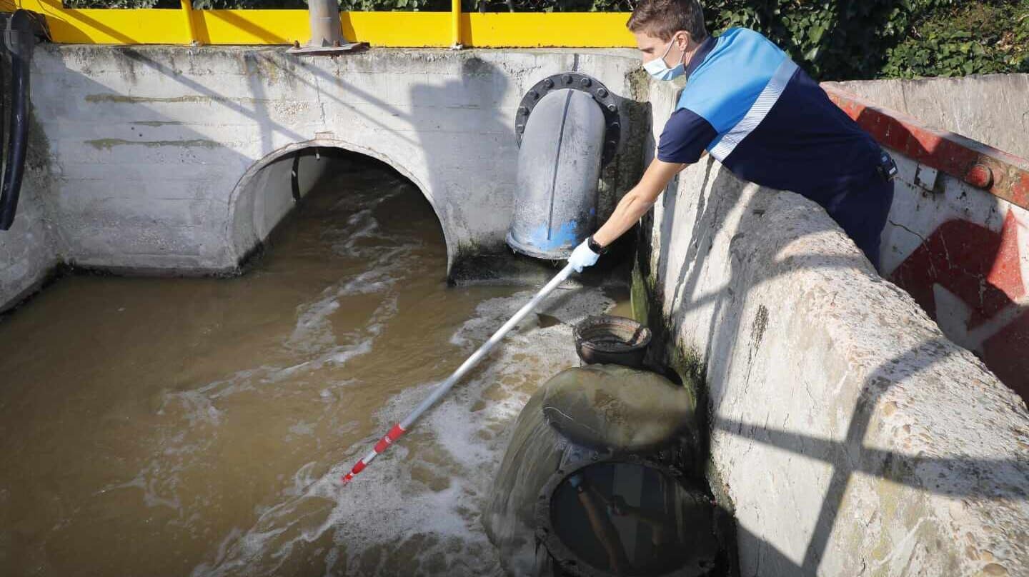 Un técnico toma muestras de aguas residuales.