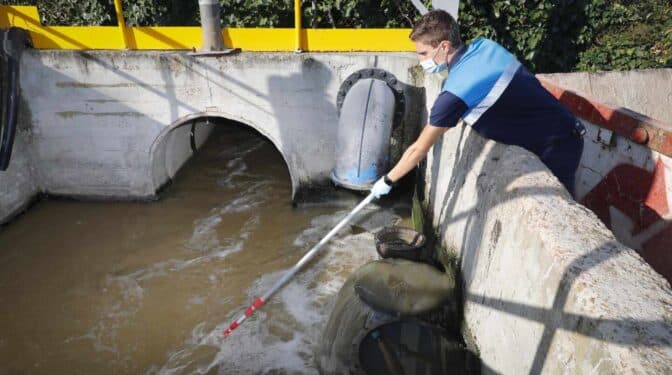 Un técnico toma muestras de aguas residuales.