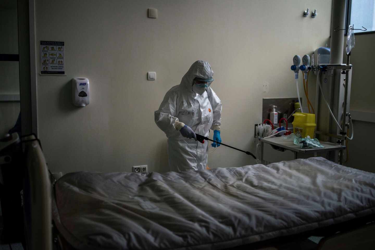 Una trabajadora del servicio de limpieza desinfecta una cama en el interior de la unidad de vigilancia postquirúrgica (REA) del Complejo Universitario de Ourense.