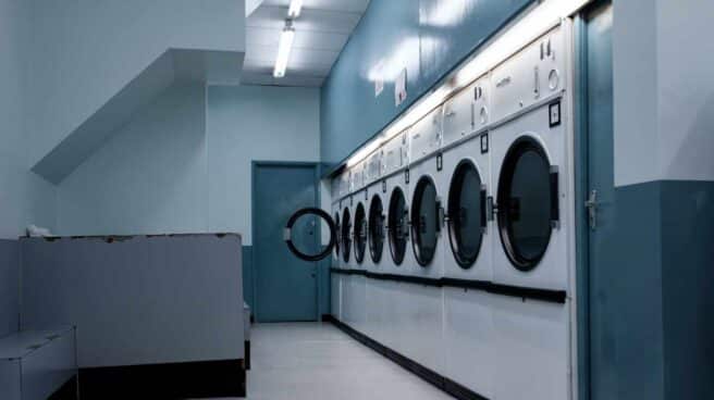 Una imagen del interior de una lavandería con muchas lavadoras