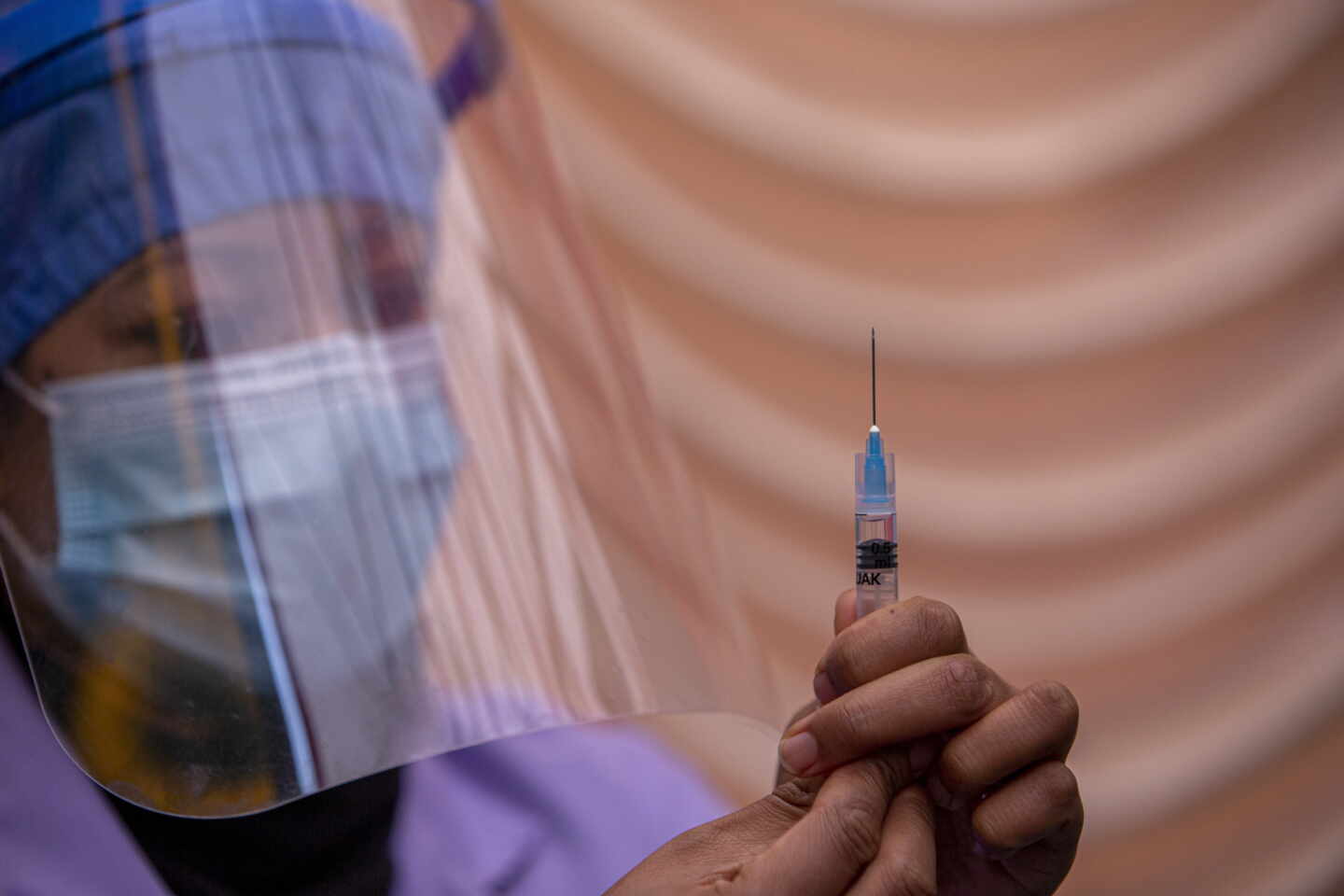 Una mujer sostiene una jeringuilla con la vacuna contra el coronavirus