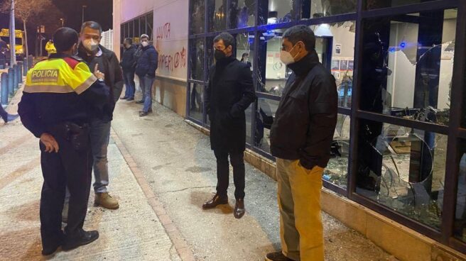 El consejero de Interior de la Generalitat, Miquel Sàmper, habla con un agente de policía frente a las cristaleras destrozadas de la Comisaría de los Mossos en Vic durante las protestas por la detención del rapero Pablo Hasel.