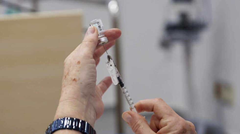 Una sanitaria sostiene el material para la aplicación de un vacuna de Pfizer