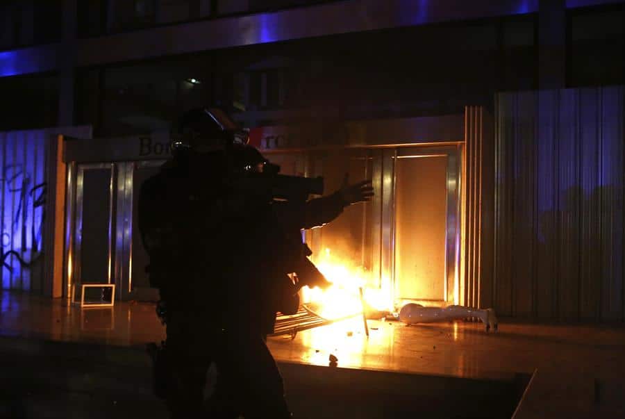 Un mosso, frente a la entrada en llamas de la Bolsa de Barcelona.