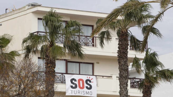 Un cartel colgado de un edificio donde se puede leer "SOS Turismo" en Baleares.