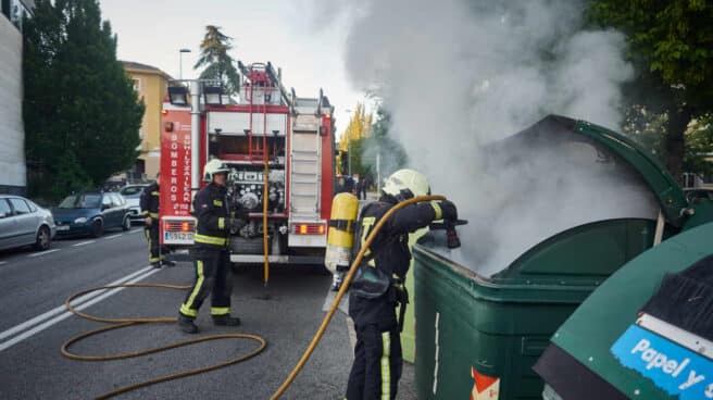 Una dotación de bomberos apaga un contenedor de basura durante una manifestación en el barrio de la Txantrea de Pamplona en apoyo al preso etarra Patxi Ruiz, en mayo de 2020.