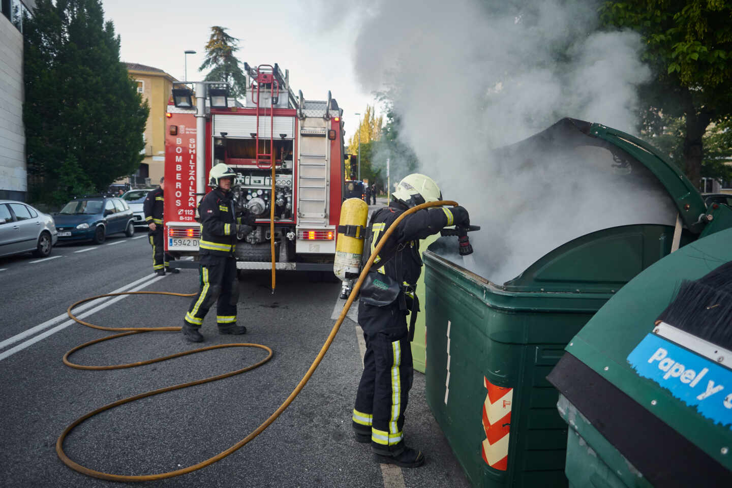 Una dotación de bomberos apaga un contenedor de basura durante una manifestación en el barrio de la Txantrea de Pamplona en apoyo al preso etarra Patxi Ruiz, en mayo de 2020.