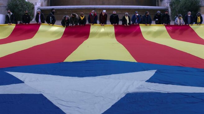 Miembros de la ANC despliegan una estelada en el centro de Barcelona.