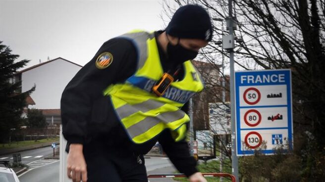 Policía francés con una señal de alto en la frontera de Francia