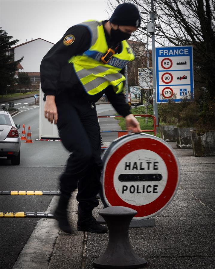 Policía francés con una señal de alto en la frontera de Francia