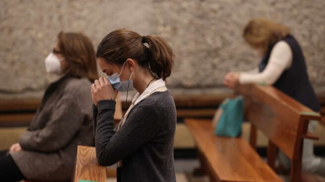 Una mujer reza durante la celebración de una Misa en la parroquia de Santa Elena (Madrid). Una mujer reza durante la celebración de una Misa en la parroquia de Santa Elena (Madrid).