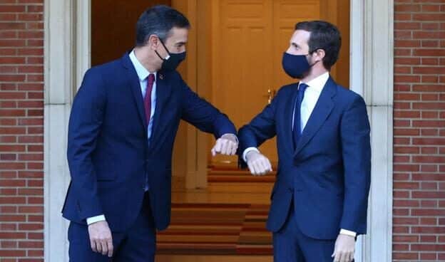 Pedro Sánchez y Pablo Casado, con mascarillas, se saludan chocando el codo en una entrevista que mantuvieron en Moncloa