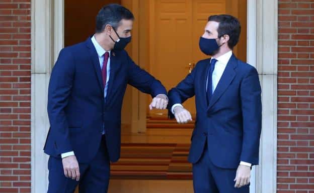 Pedro Sánchez y Pablo Casado, con mascarillas, se saludan chocando el codo en una entrevista que mantuvieron en Moncloa