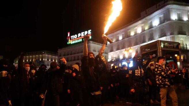 Manifestantes se enfrentan a los agentes de la policía antidisturbios durante una marcha por la detención del rapero Pablo Hasel, que ayer ingresó en prisión, condenado por delitos de enaltecimiento del terrorismo e injurias a la Corona, este miércoles en la madrileña Plaza de Sol.