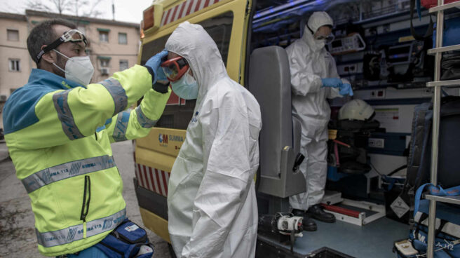 Madrid mejora: suben ligeramente los casos, pero bajan las muertes y la presión hospitalaria Un trabajador de una UVI móvil del SUMMA 112 se viste con un EPI, en Madrid.