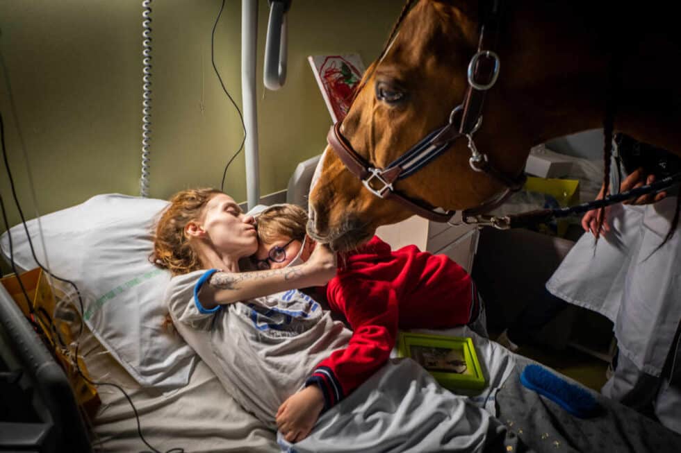 Manon, que tiene cáncer metastásico, abraza a su hijo Ethan en presencia de Peyo, un caballo utilizado en terapia asistida por animales, en la Unidad de Cuidados Paliativos Séléne en el Centro Hospitalario de Calais, en Calais, Francia. el 30 de noviembre.