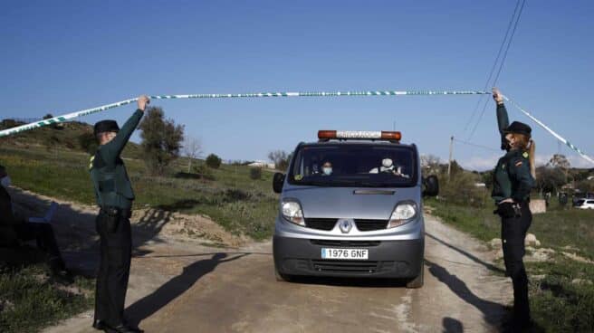 Un furgón de las unidades forenses custodiado por un Guardia Civil