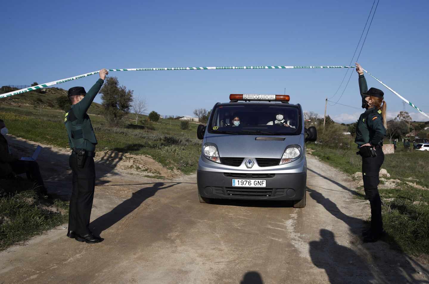 Un furgón de las unidades forenses custodiado por un Guardia Civil