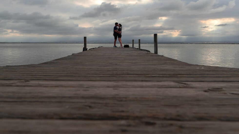 Una pareja se besa al final del embarcadero del Parque Natural de La Albufera en las inmediaciones de la localidad de El Palmar, en Valencia, Comunidad Valencia (España)