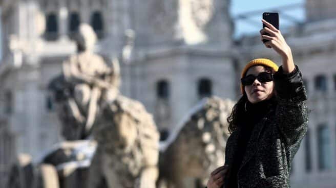 Una mujer se hace un selfie junto a la estatua de Cibeles en Madrid.