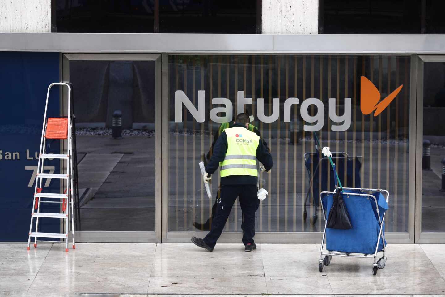 Un operario limpia la cristalera de la sede de Naturgy ubicada en la capital, Madrid, (España), a 26 de enero de 2021.