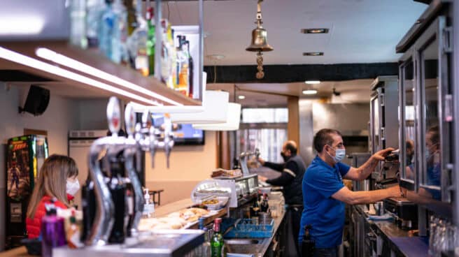 Un trabajador prepara un café en un bar. Un trabajador prepara un café en un bar.