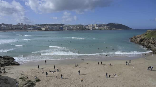 Varias personas disfrutan de la playa del Orzán en A Coruña.