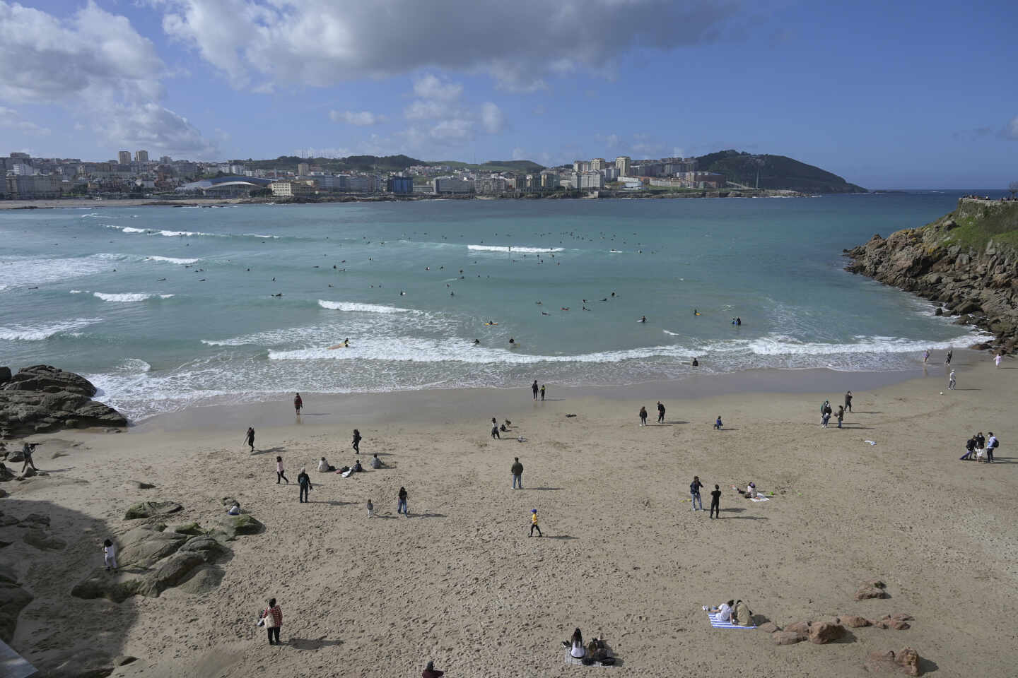 Varias personas disfrutan de la playa del Orzán en A Coruña.