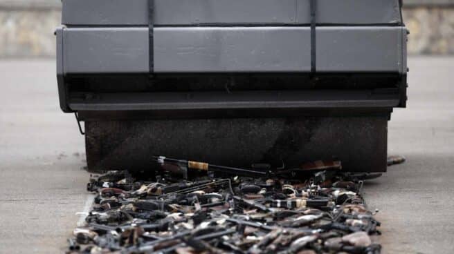 Una apisonadora pasa por encima de varias armas. Una apisonadora pasa por encima de varias armas.
