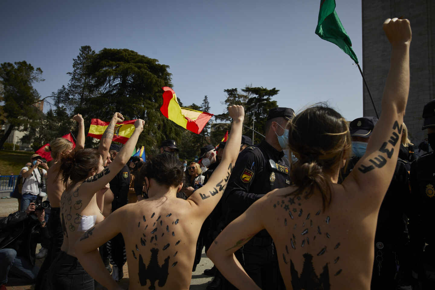 Activistas de Femen con águilas franquistas dibujadas en la espalda durante un acto por el Día de la Victoria, en Madrid
