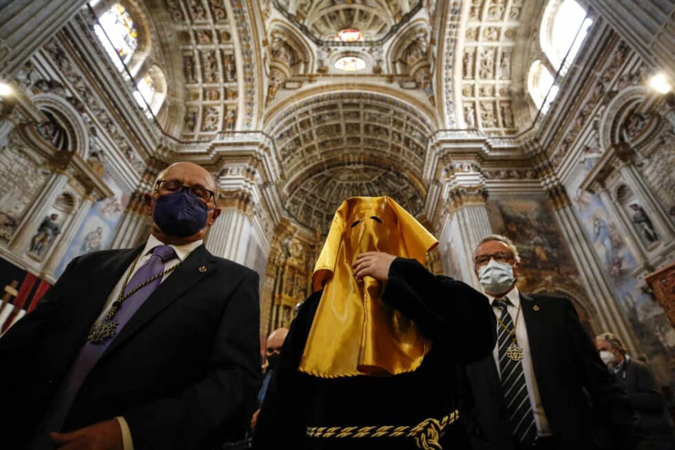 El interior de una iglesia y personas con mascarillas por Semana Santa