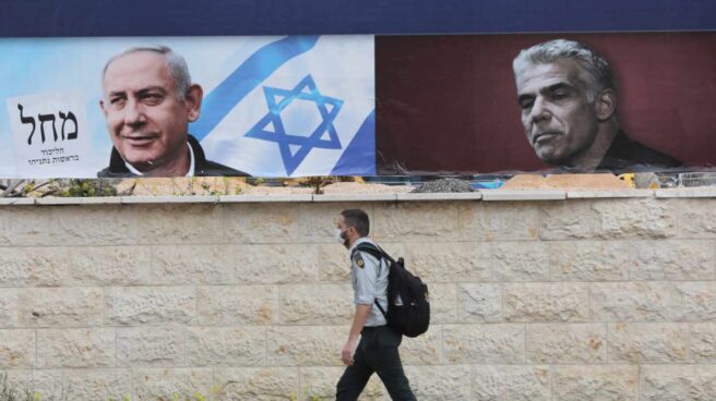 Israel vota por cuarta vez en dos años en un plebiscito sobre Netanyahu Un israelí pasa cerca de dos carteles electorales, uno de ellos de Netanyahu