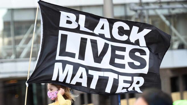 Una niña porta una bandera que dice 'las vidas de los negros importan" en Minneapolis