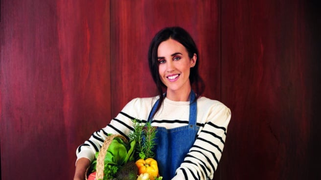 La influencer fitness Patry Jordan con un cesto de verduras en el regazo