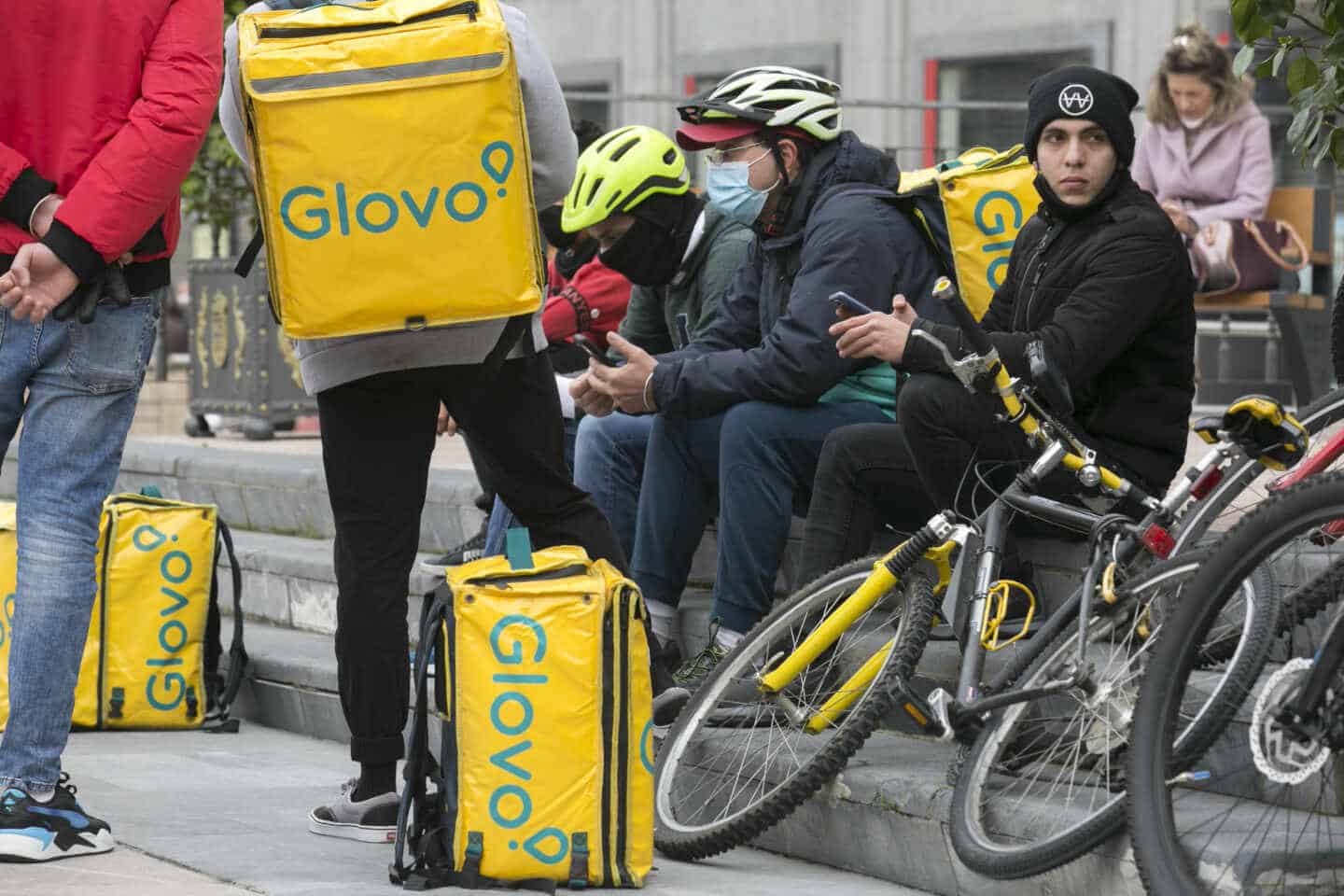 Un grupos de repartidores 'riders' descansando entre los pedidos