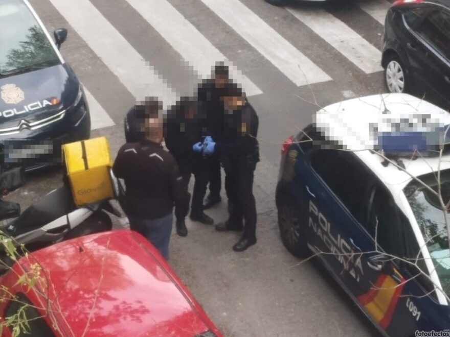 Policía que registra a un rider de Glovo para ver si lleva porros a domicilio