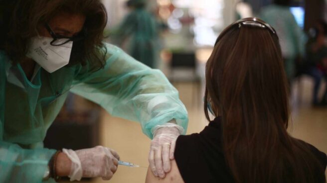 Madrid vacunará a los mayores de 16 años desde el martes 13 Una farmacéutica recibe una vacuna contra el coronavirus en Madrid
