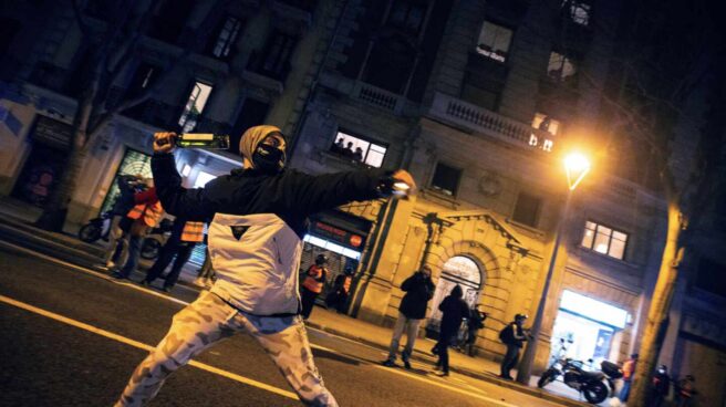 Un manifestante se dispone a lanzar una botella a la policía durante una protesta en Barcelona por Pablo Hasél.