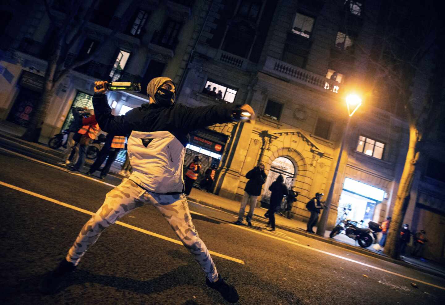 Un manifestante se dispone a lanzar una botella a la policía durante una protesta en Barcelona por Pablo Hasél.