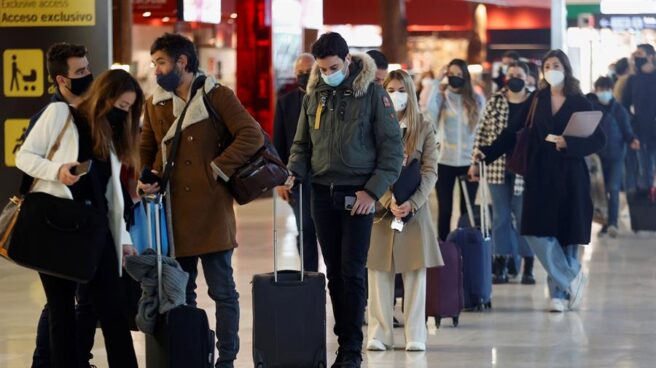Varios viajeros hacen cola ante un mostrador de facturación en el aeropuerto Adolfo Suárez Madrid-Barajas