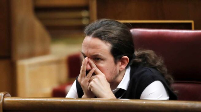 El líder de Podemos, Pablo Iglesias, se toca la cara durante el debate de investidura de Pedro Sánchez.