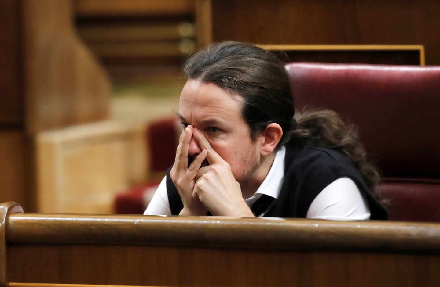 El líder de Podemos, Pablo Iglesias, se toca la cara durante el debate de investidura de Pedro Sánchez.