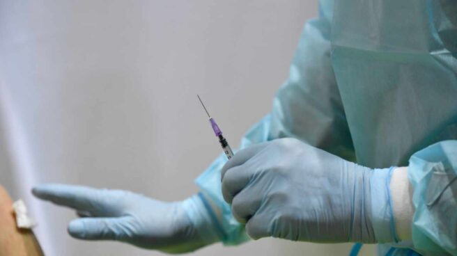 Una sanitaria se prepara para administrar una vacuna.